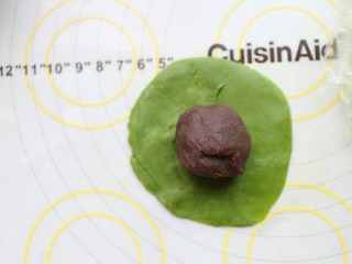 7、抹茶冰皮月饼,将25克的豆沙馅放在上面，包裹好，揉圆