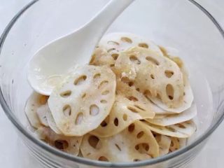 4、香辣藕片,将藕片沥干水分放入容器中，再调入生抽、醋、糖、盐和香油拌匀，调味料的用量就是用图中那个白色汤匙来量的，也可以按照个人的口味来调配。