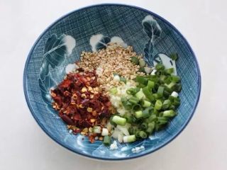 5、香辣藕片,取一个小碗放入蒜末、葱花、辣椒面和芝麻。