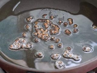 6、香辣藕片,锅中倒适量食用油烧至五成热，再放入一小撮麻椒粒，小火慢慢炒出香味，然后将麻椒粒捞出丢弃。