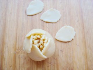 7、#甜味#花好月圆创意月饼,围绕着花蕊面团，一片压住另一片的三分之一处，粘贴住。