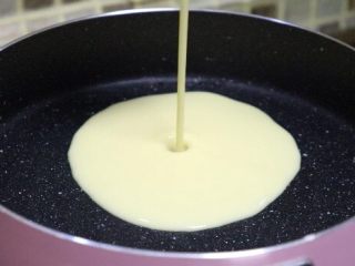 4、简单快手鸡蛋卷,锅里刷一层油，倒入一勺面糊。