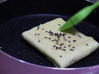 7、简单快手鸡蛋卷,翻面儿刷少许油，撒上芝麻，煎成金黄色。