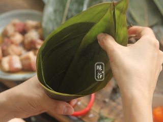8、粤式海鲜咸肉粽,取2片粽叶错开一点相叠，折成一个漏斗形；