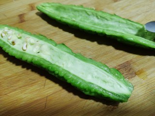 3、苦瓜煎蛋,从中间切开用小勺刮去里面的瓜瓤,刮得越干净越好