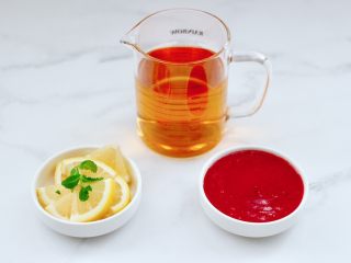 6、蔓越莓草莓花茶饮,把柠檬洗净后用刀切成片，榨好的蔓越莓草莓泥盛到碗里。