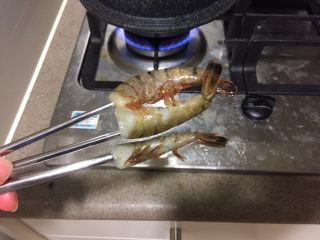 12、中华冷面,新鲜大虾,去头,别扔,留着做虾汤,或者虾油。掰直虾身,用竹签或筷子串起来,保持虾是直的。