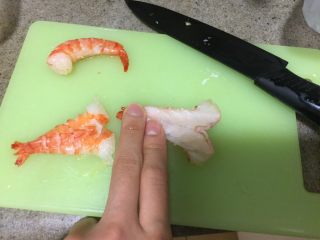 14、中华冷面,然后从竹签上拿下来,去壳。从虾的腹部切开,但不要切到底,去掉虾泥。然后压平。