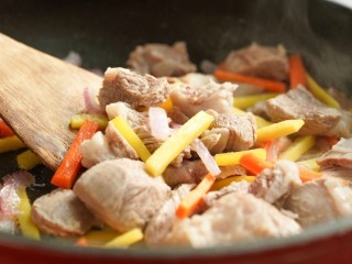 7、新疆特色手抓饭,加入胡萝卜条和羊肉，继续翻炒均匀