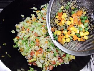 12、炒饭秀＋蒜香时蔬藜麦饭,再把提前煮好的藜麦和青豆玉米胡萝卜全部放入炒锅里。