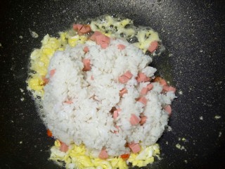 6、#圆土豆#火腿黄金炒饭,在把之前搅拌好的剩饭一起倒进来翻炒,这个时候用大火,快炒