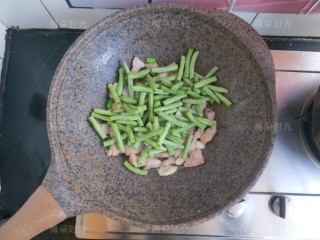 6、豆角焖面,倒入豆角翻炒。