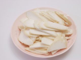 2、蛋黄煎杏鲍菇,杏鲍菇用清水洗净，切掉尾部老根部分，然后对半切成两瓣，再竖着切成大小均匀的薄片