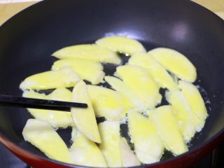 9、蛋黄煎杏鲍菇,将杏鲍菇片撇去多余的蛋糊后放入锅中