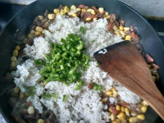 11、腊肠炒饭,倒入青椒翻炒。