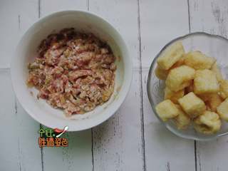 2、豆腐泡塞肉,肉末中加入酸菜剁碎、盐、酱油、胡椒粉、生粉,加入一勺水向着同一个方向搅拌至起胶,加入葱花姜末搅拌均匀;