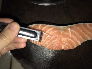 2、三文鱼炒饭,腌好的三文鱼洗净，用厨房纸巾吸干水分，切去中间的骨，然后用夹子夹出骨刺。