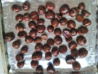 9、糖烤板栗,烤箱预热后，烤盘铺上锡箔纸，把板栗平铺在烤盘上入烤箱中层，200度。