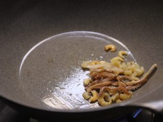 4、潮汕砂锅粥,热锅热油,将泡好的干鱿鱼,干贝,虾米放入炒香(单纯的加入到粥里的话,会比较腥哈,炒一炒,除了去除它们的海腥味,还能增加香味,这一步很重要,记得圈起来)