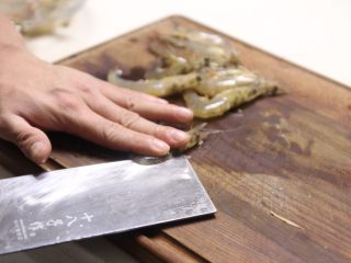 7、潮汕砂锅粥,今天做的海鲜砂锅粥,所以我选择用到虾,记得,购买新鲜的虾,用图中的手法,将虾开背,放置一边待用,虾头记得不能去掉哈,海鲜粥的鲜味来之与虾的虾头,去掉,粥就不鲜了。