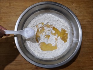 2、霜糖油条,在350克面粉中加入15克油，3克酵母粉和3克盐搅拌均匀。