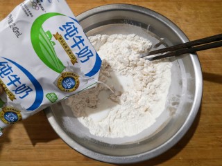 3、霜糖油条,在加入适量纯牛奶(牛奶的加入量根据你用的面粉的吸水率来决定，我用了大概200毫升左右，以和起的面团不软和不粘手为宜）。