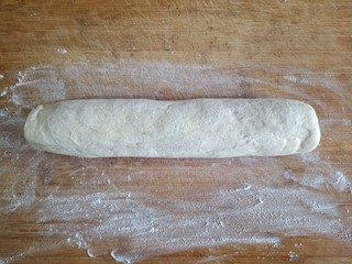 7、霜糖油条,面板上撒一层薄粉，发面取出后不要揉，直接在面板上轻轻搓成圆柱形。