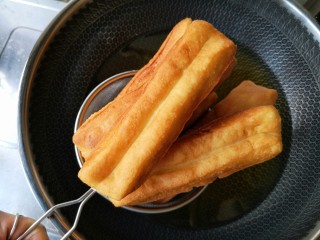 15、霜糖油条,炸成金黄色后沥油捞出。