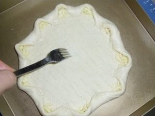 8、蘑菇培根披萨,将饼皮隔一段往里翻成花型,按紧,在饼皮上用叉子叉些小眼防膨胀