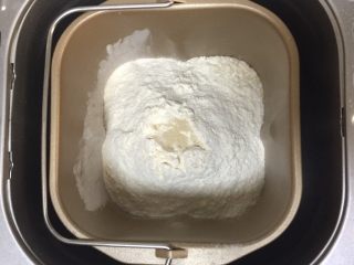 1、蔓越莓椰蓉千层吐司,面包机中加入高筋粉，盐，中间戳个洞，放上酵母粉。