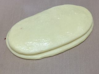 11、蔓越莓椰蓉千层吐司,再叠加一个擀好的长舌状面团，刷一层炼乳。大小尽量一致