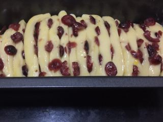 14、蔓越莓椰蓉千层吐司,把横切面朝上放置在四周刷了油的吐司盒里，正好摆满。放在烤箱里，烤箱底层的烤盘里倒上热水，进行二次发酵