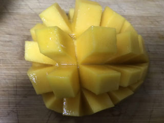 1、芒果布丁????,准备一个芒果切开划十字花刀