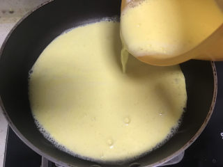 6、芒果布丁????,把打好的芒果奶昔放入不粘锅