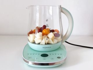 3、冰糖雪梨金桔饮,往康佳养生壶内加入雪梨、金桔、红枣和冰糖。