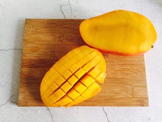 2、芒果西米露,芒果中间切开，用刀划好十字格