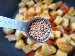 11、孜然火腿馒头丁,倒入白芝麻。