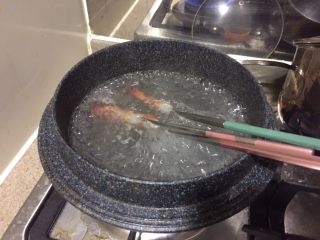 13、中华冷面,把水煮沸,放入串好的虾,煮1分钟,捞出来。放入冰水里,冰镇一下。