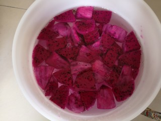 3、火龙果酵素,接着将火龙果切成块状放入桶中。