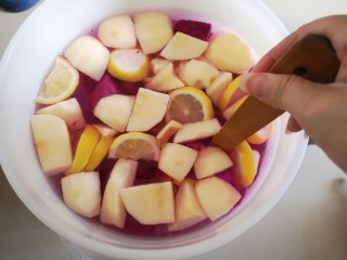 4、火龙果酵素,再将苹果和柠檬切成块和片状放入，用木勺将糖搅拌均匀。