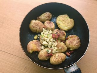 13、椒盐土豆,两面煎好后转大火,放入蒜末和辣椒碎,炒香。