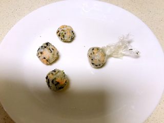 16、三文鱼紫菜饭团,把保鲜膜提起来捏紧,饭团做好了