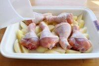 5、苹果柠香烤鸡腿,沿四周浇点水，水量根据盘子的大小，略高于底面即可；然后将烤盘放进已经预热的烤箱，200度25分钟左右