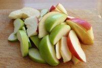 6、苹果柠香烤鸡腿,在烤的同时，我们将苹果洗净、去核、切成船形，挤点柠檬汁。注:这里柠檬汁的作用是防氧化，增味