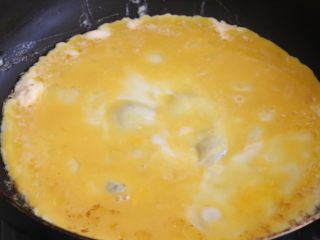 12、日式蛋包饭,倒入鸡蛋液，将鸡蛋摊平。