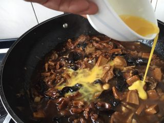 15、老天津卫三鲜打卤面,浓稠度以卤汁能挂在面上为好，这是勾完芡的样子，这时候改小火，碗里留少许水淀粉，把鸡蛋打散，用筷子挡往下流鸡蛋液的碗边，让鸡蛋液顺着筷子和碗边的空隙往下流，要转圈洒鸡蛋液，让蛋液均匀分散在锅里，这时要有点小耐心等待蛋液定型哦。不过这步可以略去，您也可以把鸡蛋提前炒好，撒在盛在盆里的卤上，这样的做法叫盖冒。