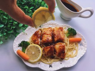 12、黑椒巴沙鱼意面,盘底铺意面，摆上鱼柳，倒上酱汁，吃前挤上柠檬汁～