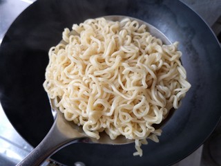 10、十味 鲜虾鱼板面,将煮好的面沥水捞出（可过一下凉开水增加面的弹性），煮面的水倒掉。