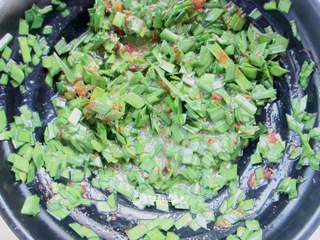 4、家常韭菜饼,加入一勺油,盐、辣椒粉、鸡粉、胡椒粉搅拌均匀