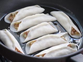8、脆底猪肉洋葱锅贴,锅中刷一层花生油，将包好的锅贴依次排放锅中